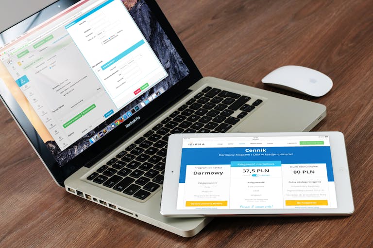 Small Business Website Design In Charlotte, Nc: What To Expect From Start To Launch 3 Close-up of a laptop and tablet on a wooden desk, showcasing modern technology.