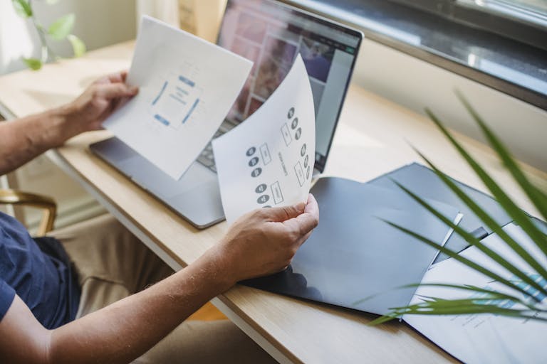5 Signs It'S Time To Hire A Web Designer In Charlotte, Nc 2 Crop anonymous male designer in casual wear sitting at table with opened laptop and folders and reading papers